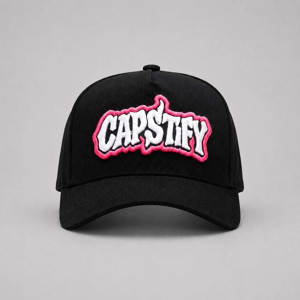 Front view of the Capstify Skull Voltage A-Frame baseball cap in black featuring a bold white and pink 3D puff embroidered Capstify logo on the front panel.
