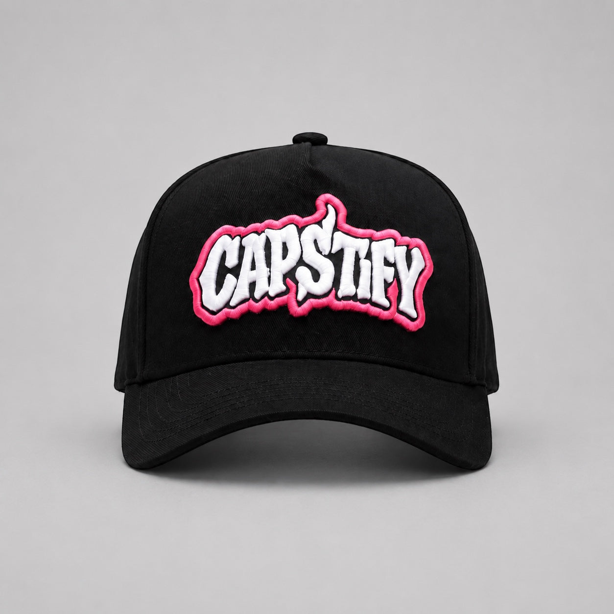 Front view of the Capstify Skull Voltage A-Frame baseball cap in black featuring a bold white and pink 3D puff embroidered Capstify logo on the front panel.