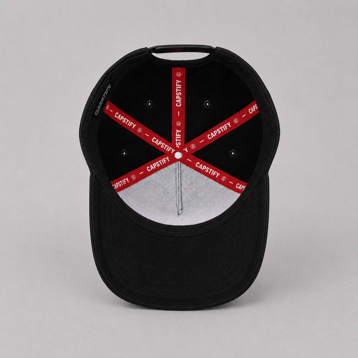 Interior view of the Capstify Skull Voltage black A-Frame baseball cap featuring a premium custom red Capstify branded inner tape, reinforced stitched panels, breathable eyelets, and a structured crown.