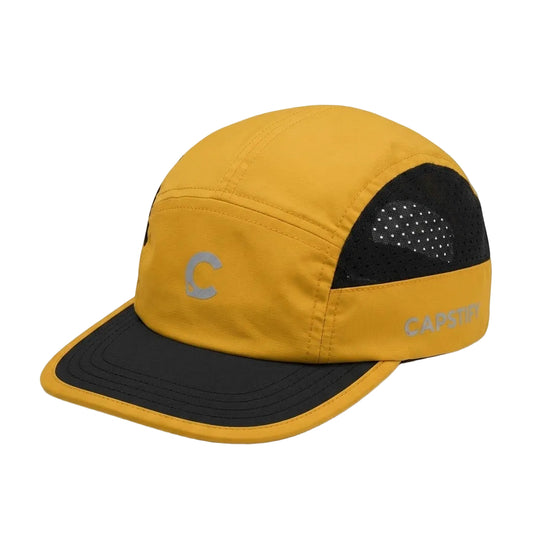 A yellow and black 5-panel cap with a curved brim, featuring a gray reflective 'C' logo on the front panel and 'CAPSTRIP' branding on the side, set against a plain white background.