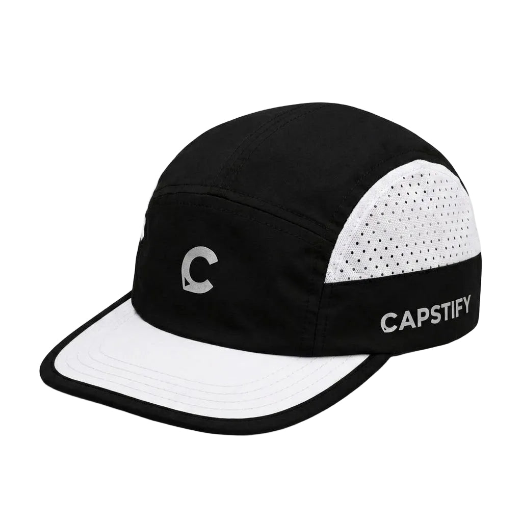 A black and white 5-panel camp cap with a white perforated back panel, a white brim, a silver 'C' logo on the front, and 'CAPSTIFY' printed in white on the side.